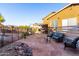 Charming backyard with a stone patio, outdoor seating, and lush landscaping at 17466 N 64Th Ave, Glendale, AZ 85308