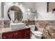 Bathroom featuring an oval mirror above the sink and a tile backsplash at 17466 N 64Th Ave, Glendale, AZ 85308