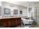 The stylish bathroom boasts a double vanity, clawfoot tub, and a glass-enclosed shower, creating a luxurious retreat at 17466 N 64Th Ave, Glendale, AZ 85308