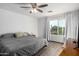 Bright bedroom with wood floors, a ceiling fan, and a large window with curtains at 17466 N 64Th Ave, Glendale, AZ 85308
