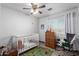 Charming Bedroom featuring a crib, dresser, and soft rug, creating a warm and inviting space for a baby at 17466 N 64Th Ave, Glendale, AZ 85308