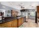 Open-concept kitchen showcasing granite countertops, wooden cabinets, and a bar area with seating at 17466 N 64Th Ave, Glendale, AZ 85308