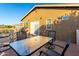 Outdoor patio featuring a glass-top dining table, chairs, and a well-manicured backyard at 17466 N 64Th Ave, Glendale, AZ 85308