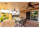 Covered outdoor patio with ceiling fans, dining table, and stone flooring at 17466 N 64Th Ave, Glendale, AZ 85308