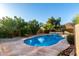 Backyard featuring a freeform pool and spa surrounded by desert landscaping at 17466 N 64Th Ave, Glendale, AZ 85308