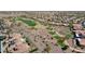 Aerial view of desert homes nestled adjacent to a lush green golf course with mature trees at 20453 N 264Th Ave, Buckeye, AZ 85396