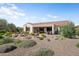 This landscaped backyard features a fire pit, a covered patio, and beautiful desert plants at 20453 N 264Th Ave, Buckeye, AZ 85396