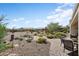 This landscaped backyard features a fire pit, a covered patio, and beautiful desert plants at 20453 N 264Th Ave, Buckeye, AZ 85396