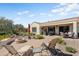 This landscaped backyard features a fire pit, a covered patio, and beautiful desert plants at 20453 N 264Th Ave, Buckeye, AZ 85396