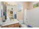 This bright bathroom features a shower-tub combination, a large mirror, and wood cabinets at 20453 N 264Th Ave, Buckeye, AZ 85396