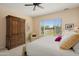 Bright bedroom featuring a ceiling fan, window with blinds, and a large wooden wardrobe at 20453 N 264Th Ave, Buckeye, AZ 85396