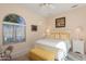 Bright bedroom featuring a window, bedside tables, and a white bedframe with yellow pillows at 20453 N 264Th Ave, Buckeye, AZ 85396