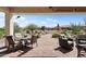 This covered patio boasts plenty of seating and views of the landscaped backyard with desert plants at 20453 N 264Th Ave, Buckeye, AZ 85396