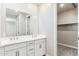 Elegant bathroom featuring double sink vanity, modern fixtures, and a well-organized walk-in closet at 21232 N 58Th St, Phoenix, AZ 85054