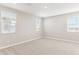 Spacious bedroom with plush carpeting and multiple windows providing plenty of natural light and a view of the surrounding landscape at 21232 N 58Th St, Phoenix, AZ 85054