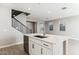 Close-up view of the kitchen island featuring a modern faucet, white cabinets, and ample counter space for meal preparation and dining at 21232 N 58Th St, Phoenix, AZ 85054