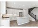Well-appointed kitchen with white cabinets, stainless steel appliances, and a functional island with a sink, adjacent to the staircase at 21232 N 58Th St, Phoenix, AZ 85054