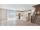 Bright, open-concept living area with modern kitchen, stylish staircase, and wood-look tile floors at 21248 N 58Th St, Phoenix, AZ 85054