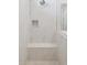 All white marble shower with rain style shower head, built in niche, and bench at 21248 N 58Th St, Phoenix, AZ 85054