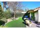 Serene backyard oasis with synthetic grass, lush landscaping, and charming patio seating at 25 E San Miguel E Ave, Phoenix, AZ 85012