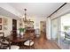 Warm dining room with a stylish chandelier, beautiful hardwood floors, and sliding glass doors for indoor-outdoor entertaining at 25 E San Miguel E Ave, Phoenix, AZ 85012