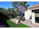 Outdoor patio featuring a dining table with umbrella, brick pavers, and lush green landscaping at 25 E San Miguel E Ave, Phoenix, AZ 85012