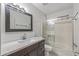 Bathroom features a vanity with a dark wood cabinet, marble countertop, and glass-enclosed shower/tub combo at 2828 E Waltann Ln # 1, Phoenix, AZ 85032