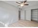A cozy bedroom features wood-look flooring and a ceiling fan, leading to a closet with shelving at 2828 E Waltann Ln # 1, Phoenix, AZ 85032