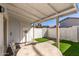 Cozy covered patio area with a white brick privacy wall and artificial grass at 2828 E Waltann Ln # 1, Phoenix, AZ 85032
