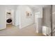Hallway with beige carpet leads to a laundry room and secondary bedroom with art on the wall at 2843 W Eagle Talon Rd, Phoenix, AZ 85085