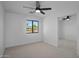 Bright bedroom with ceiling fan, mirrored closet doors, and a large window with a neighborhood view at 3417 E Lupine Ave, Phoenix, AZ 85028