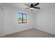 Bedroom features ceiling fan, large window with a view, and neutral carpet flooring at 3417 E Lupine Ave, Phoenix, AZ 85028