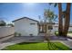 Charming home exterior with a well-maintained lawn, desert landscaping and a white exterior at 3417 E Lupine Ave, Phoenix, AZ 85028