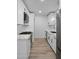 Modern galley kitchen features white cabinets, quartz countertops, stainless steel appliances, and new flooring at 3417 E Lupine Ave, Phoenix, AZ 85028