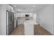 Modern white kitchen featuring stainless appliances, a center island, and wood-look floors at 3417 E Lupine Ave, Phoenix, AZ 85028
