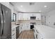 Bright kitchen boasts white cabinets, stainless steel appliances, and a spacious island with quartz countertops at 3417 E Lupine Ave, Phoenix, AZ 85028
