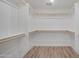 Bright, empty walk-in closet with wood-finish flooring and white shelves and rods at 3417 E Lupine Ave, Phoenix, AZ 85028