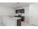 Modern kitchen featuring sleek black cabinetry, stainless steel appliances, and a stylish breakfast bar with marble countertops at 35474 N Breezy Ln, San Tan Valley, AZ 85140