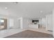 Bright, open-concept living room with tile and carpet, showcasing the kitchen and access to the outdoor patio at 35474 N Breezy Ln, San Tan Valley, AZ 85140