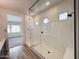 Bathroom featuring a dual-entry frameless shower, white tile walls, and natural wood-look floors at 40165 N Alameda Dr, San Tan Valley, AZ 85140
