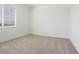 Cozy bedroom with large window providing ample natural light, plush carpet, and white walls at 40165 N Alameda Dr, San Tan Valley, AZ 85140
