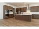 Modern kitchen with stainless steel appliances, a large island, and wood look ceramic tile flooring at 40165 N Alameda Dr, San Tan Valley, AZ 85140