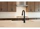 Close-up of the kitchen island featuring white counters, stylish faucet, and stainless steel appliances at 40165 N Alameda Dr, San Tan Valley, AZ 85140