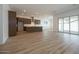 Open concept living area with kitchen, wood look ceramic tile flooring and sliding glass doors at 40165 N Alameda Dr, San Tan Valley, AZ 85140