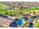 Scenic aerial view of a community with a golf course, lakes, swimming pools, and residential homes at 4214 E Donato Dr, Gilbert, AZ 85298