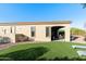 Well-maintained backyard featuring a covered patio, lush artificial turf, and comfortable lounge chairs at 4214 E Donato Dr, Gilbert, AZ 85298