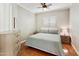 Bright bedroom with beautiful wood floors, ceiling fan, and a large window with shutters at 4214 E Donato Dr, Gilbert, AZ 85298