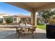 Outdoor patio with dining table, chairs, and views of the beautifully maintained backyard at 4214 E Donato Dr, Gilbert, AZ 85298