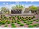 The community entrance features a modern sign with water feature, framed by manicured landscaping and inviting greenery at 5850 E Ringtail Way, Phoenix, AZ 85054