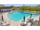 Large community swimming pool with ample lounge seating, tables, and umbrellas for relaxation at 5850 E Ringtail Way, Phoenix, AZ 85054